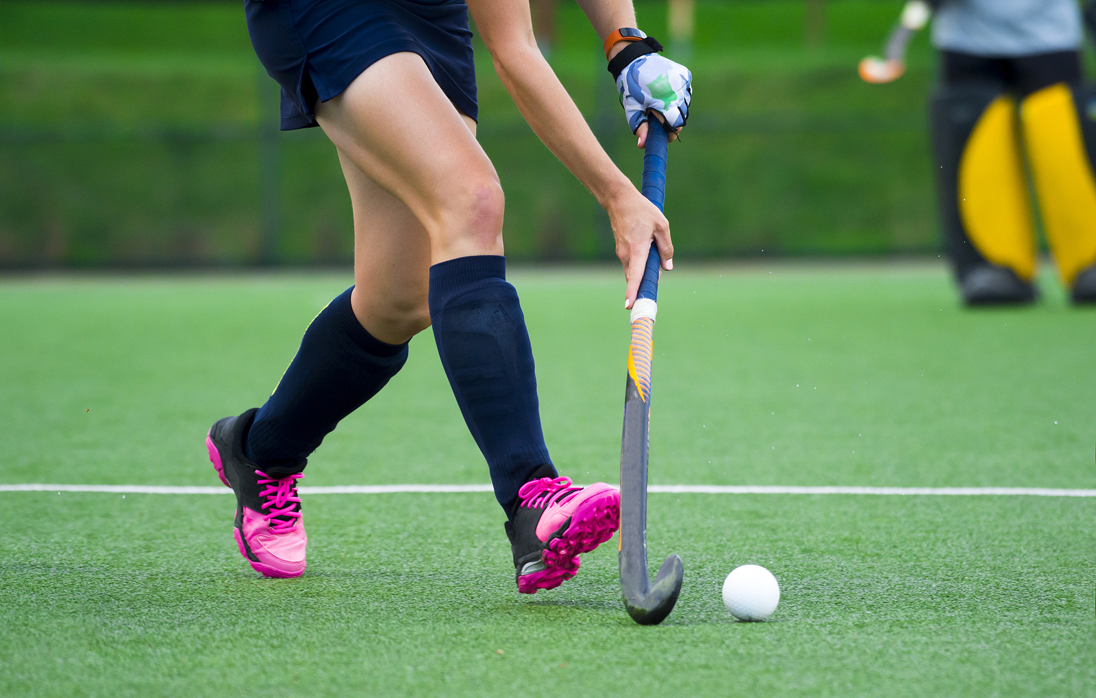 Young hockey player on artificial grass pitch