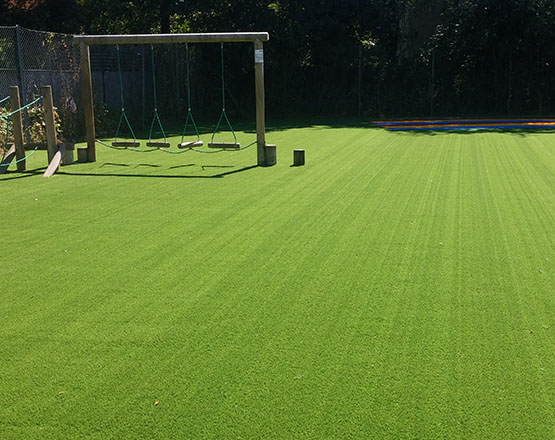 Swings safely installed on artificial grass surface