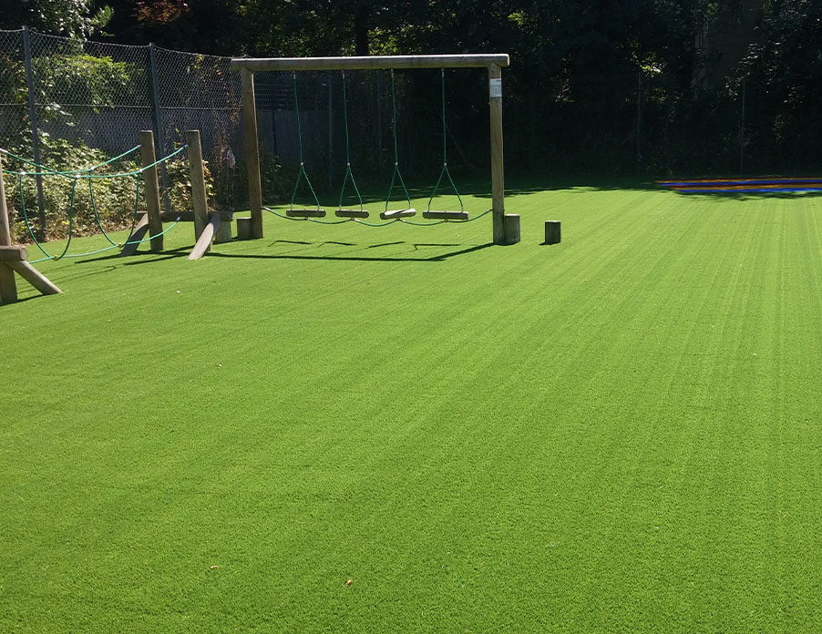 Artificial grass play area in West London with wooden swings