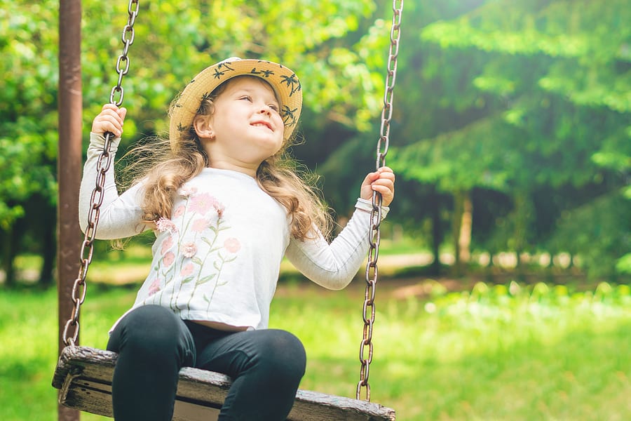 Girl enjoying a swing on grass