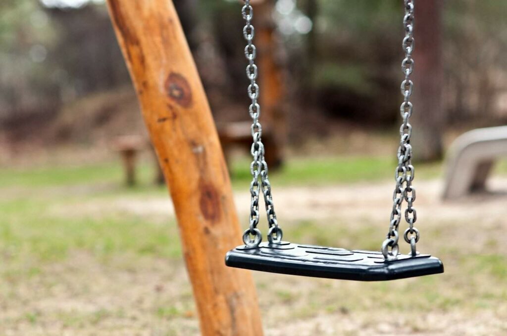 Close-up of a swing on grass play area