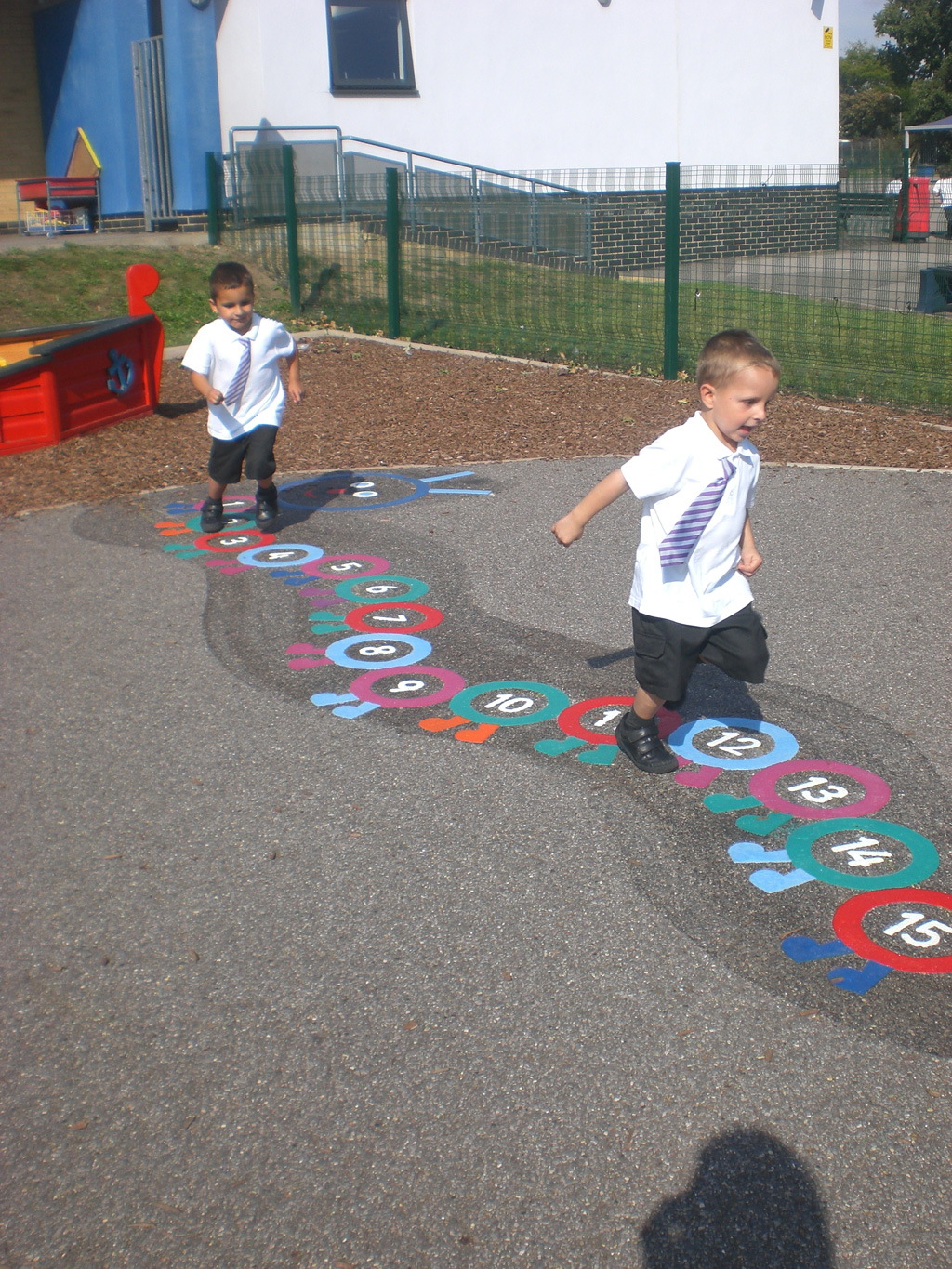 school boys running over playground markings