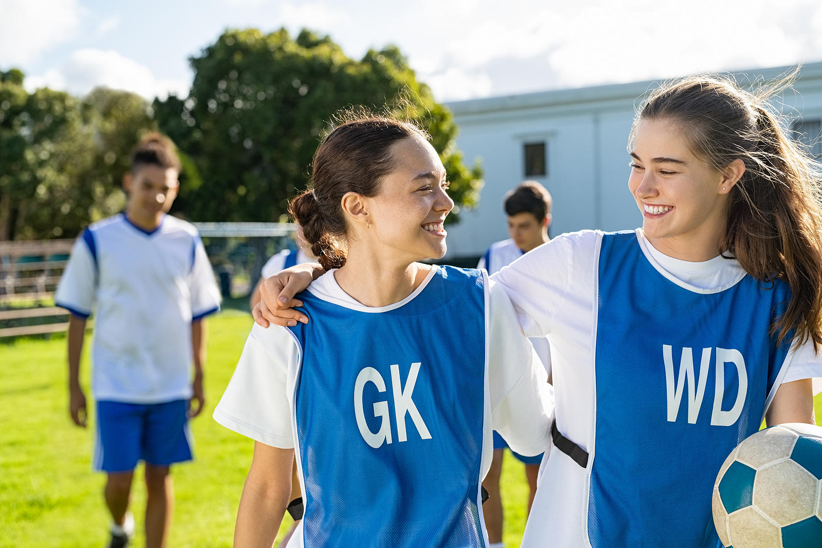 two girls in football training kit talking to each other after a school training session