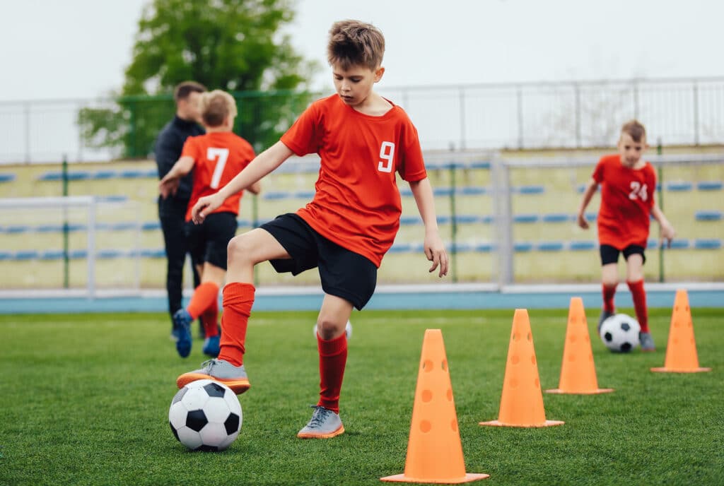 Children playing football on artificial grass